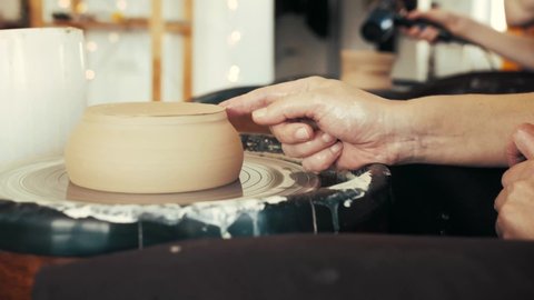 Сlay cup spinning on a potter's wheel. Сlay plate plate spins on a potter's wheel.
