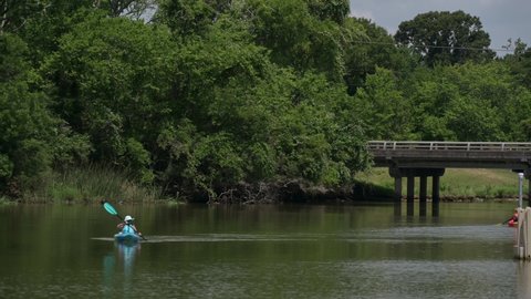 Pasadena, TX, US - June 05, 2022: A female Kayaker paddles down Armand Bayou at Bay Area Park in Pasadena Texas.