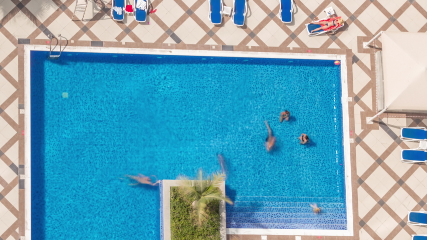 Rooftop swimming pool viewed from above timelapse, Aerial top look down view at Dubai marina. People swimming and relaxing. Dubai, UAE
