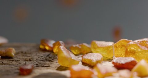 Natural amber Stone falling on a wooden plate