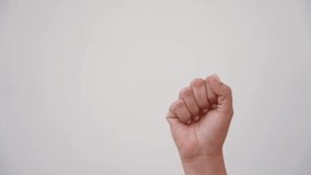 Closeup of isolated female hand showing 2 fingers up. Woman shows two fingers as sign of victory and success making V letter gesture isolated on empty white wall background