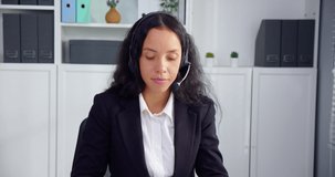 Portrait of latin businesswoman doing video conference and wearing headphonesat home office.The woman looked at the camera and spoke confidently.Operators are helping customers to get service online.