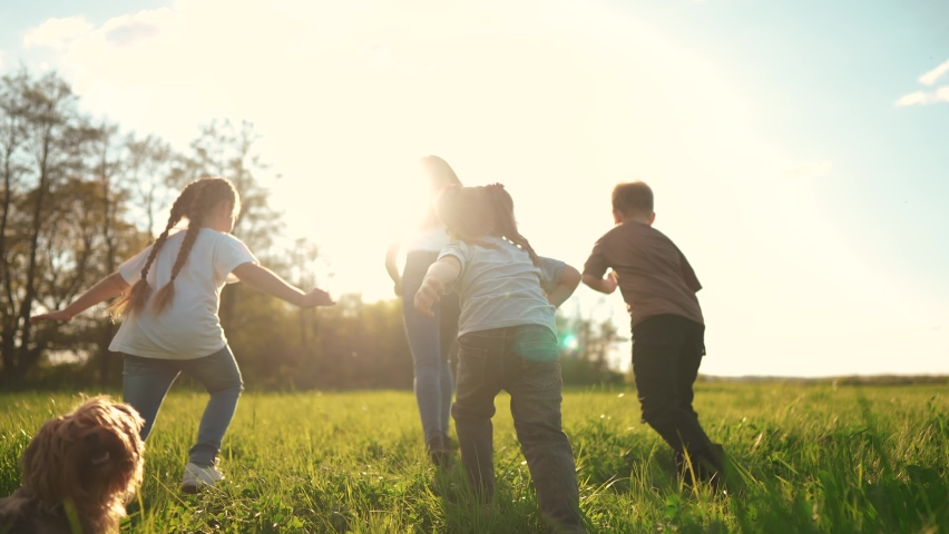 kids run in the park. a large group of a team of children running back view sunlight in the summer lifestyle on the grass in the park camera movement. people in the park happy family kid dream concept Royalty-Free Stock Footage #1091012453
