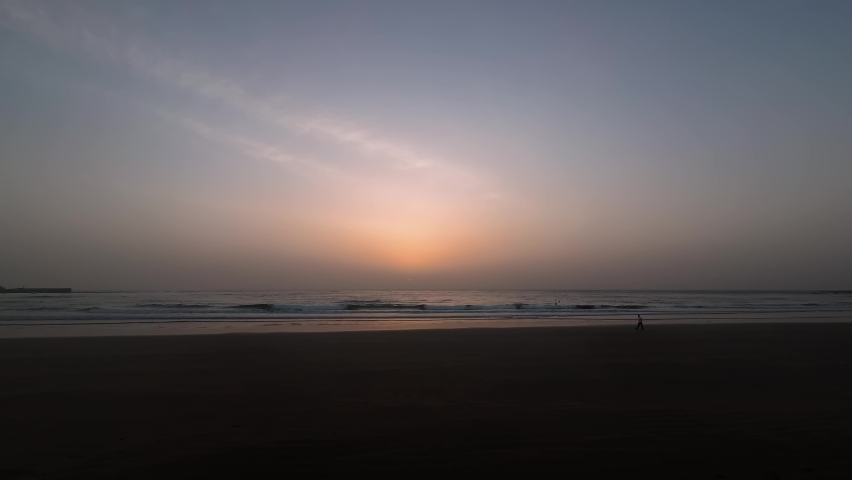 timelapse on the beach of the sea sunrise, people walk on the beach