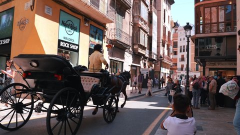 Palma De Mallorca, Spain. May 10, 2022. Horse carriages going through the narrow streets of old town of Palma De Mallorca.