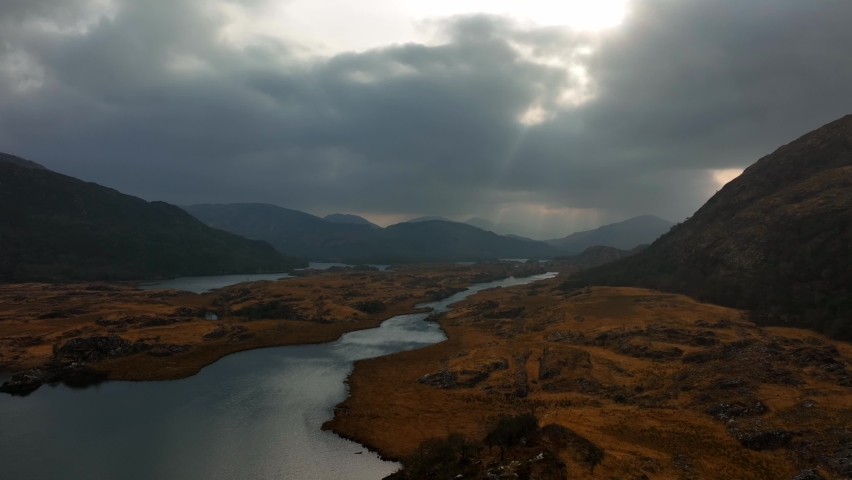 Killarney, Kerry, Ireland, March 2022. Drone pulls above the lakes and rugged landscape facing southwest towards Newfoundland Bay and the Upper Lake surrounded by the Macgillycuddy's Reeks mountains. Royalty-Free Stock Footage #1091025463