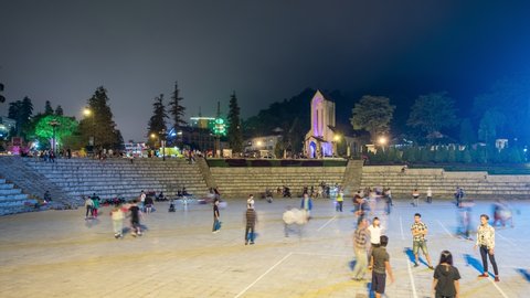 Sapa, Vietnam - Sep 07 2017 : Time-lapse of Young vietnamese playing on activity patio with Notre Dame Cathedral or Holy Rosary Church building at Sapa