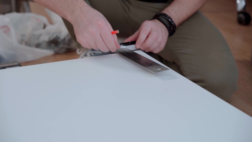 The furniture maker marks the lines with a square and pencil on the cabinet body. Furniture assembly.