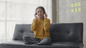 Young beautiful woman listens music in living room at home, relaxing and comfortable.