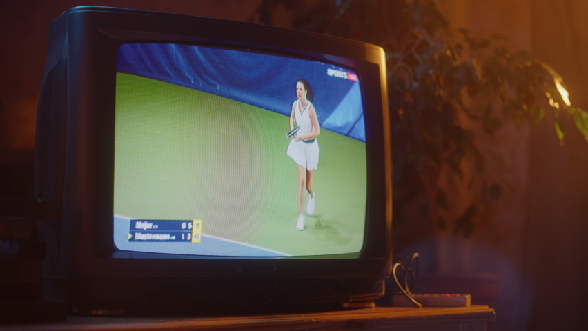 Close Up Footage of a Dated TV Set Screen with Live Sports Tennis Match Broadcast. Athletic Female Player in White Scores a Goal. Nostalgic Retro Nineties Technology Concept. Royalty-Free Stock Footage #1091044505