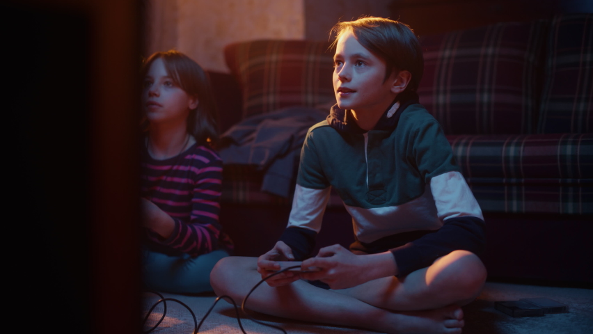 Nostalgic Childhood Concept: Young Brother and Sister Playing Arcade Video Game on a Retro Console in a Living Room with Period-Correct Interior. Friends Spend the Day at Home Playing Games. Royalty-Free Stock Footage #1091044563