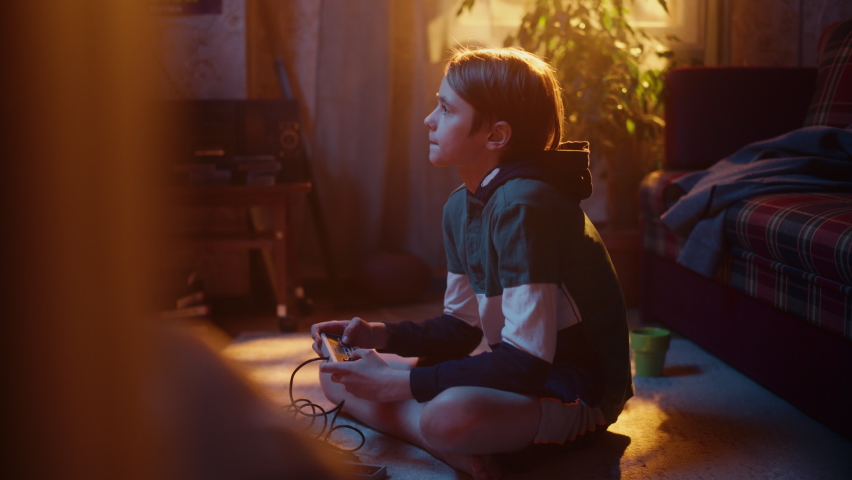 Handsome Child Playing Video Game on a Console at Home in His Room with Eighties Interior. Young Boy Reaches End of Level and Celebrates the Wins. Nostalgic Retro Childhood Concept. Royalty-Free Stock Footage #1091044615