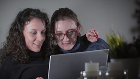 Two girls watching movie on laptop