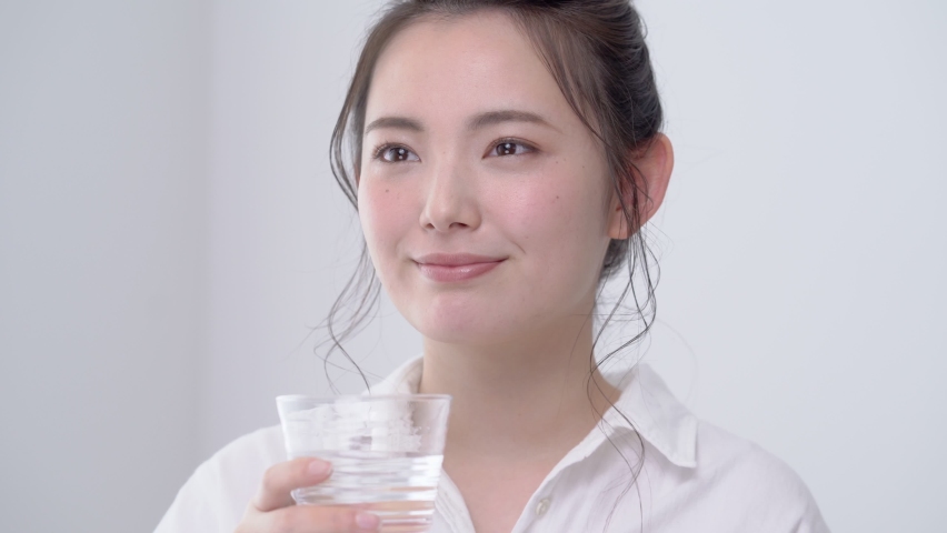 A woman drinking water in a cup Royalty-Free Stock Footage #1091045019