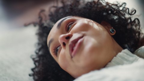 Cinematic Portrait of Black Curly Female Pointing and Laughing of Joke while Talking and Relaxing at the Floor at Home. Good Mood and Communicating Concept. Slow Motion