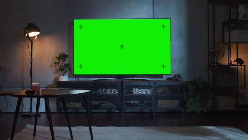 Stylish Loft Apartment Interior with TV Set with Green Screen Mock Up Display Standing on Television Stand. Empty Living Room at Home with Chroma Key Placeholder on Monitor. Zoom On Shot | Shutterstock HD Video #1091050485