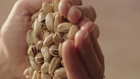 Close-up view of pistachios.Woman holding a pile of pistachios.Video for the vertical story.