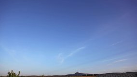 Movement of thin cirrus clouds in the blue sky above the horizon. Video time lapse