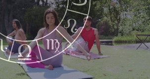 Animation of horoscope zodiac wheel over diverse people practicing yoga. Star signs, horoscope and yoga meditation concept digitally generated video.