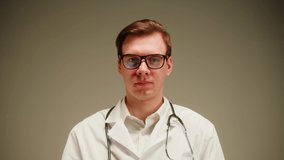Doctor portrait, nurse, therapist. Medical worker posing on grey background in studio. Man wearing stethoscope, surgical uniform and glasses looking in camera. Healthcare and medicine. - Powered by Shutterstock - Get 15% off with code: PIKWIZARD15