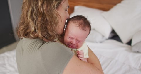Video of happy caucasian mother hugging newborn baby. motherhood, parental love and taking care of newborn baby concept digitally generated video.