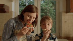 Happy family of mother and kid eating homemade pizza. 30s woman in apron enjoying pizza with her cute son. Handheld camera. - Powered by Shutterstock - Get 15% off with code: PIKWIZARD15