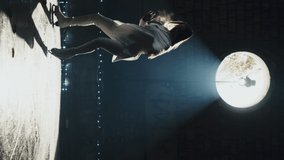 A woman skates on ice in an abandoned building. Silhouette of a female figure skater practicing spin and slide skills. Figure skating training. Skill development. Slow motion. Vertical video