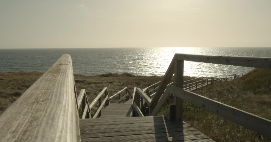 Boardwalk trough the dunes of Sylt with the Northsea in the background 4k 60fps