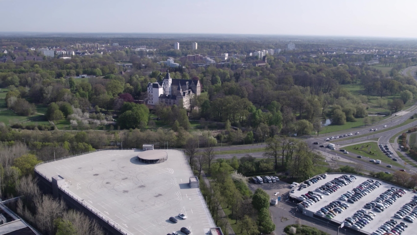 Fly in to Wolfsburg Castle over highway with cars, Germany