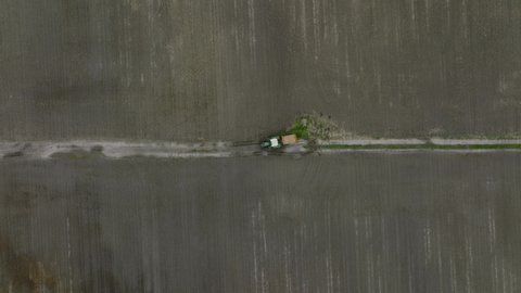 Top View Of An Agricultural Tractor Driving At The Farm. aerial drone
