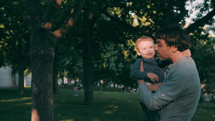 Father with son play in the park in spring. Happy family. Slow motion