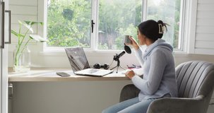 Video of biracial woman taking part in online interview on laptop at home. Home office, working from home with technology concept.