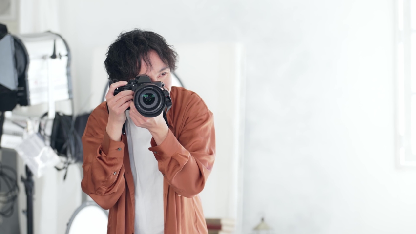 Asian photographer shooting in the studio. Digital single-lens camera. | Shutterstock HD Video #1091073677