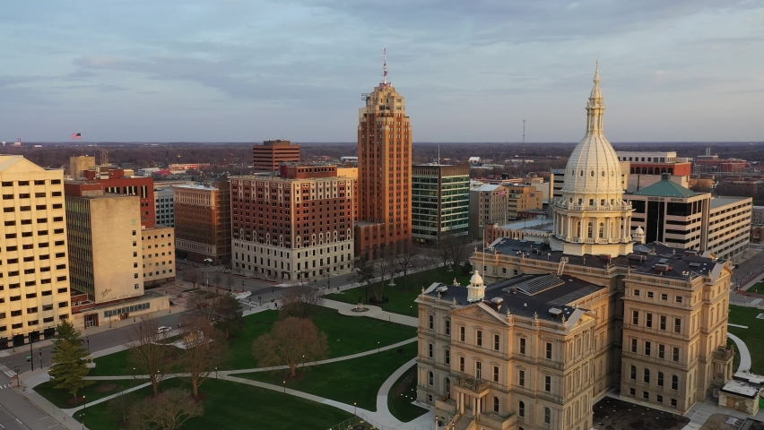 Skyline of Lansing, Michigan at sunset with aerial view of the Michigan State Capitol Building Royalty-Free Stock Footage #1091075107
