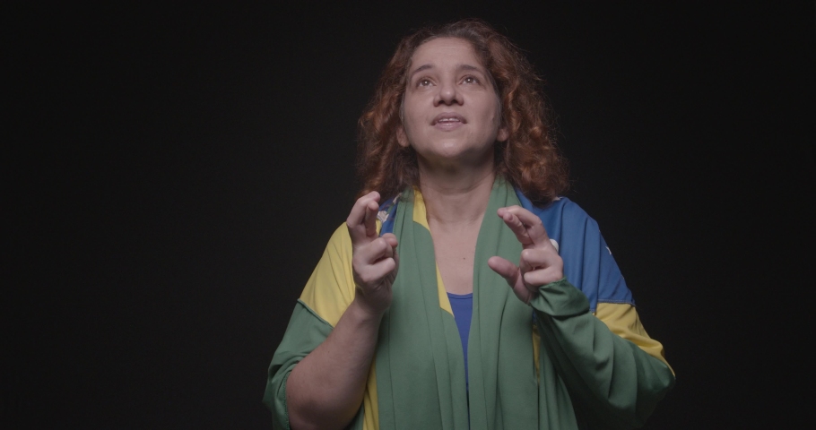 Woman supporter of Brazil, fan of Brazil, World Cup, Olympics, fingers crossed Luck, wishing, hope, wanting | Shutterstock HD Video #1091075973