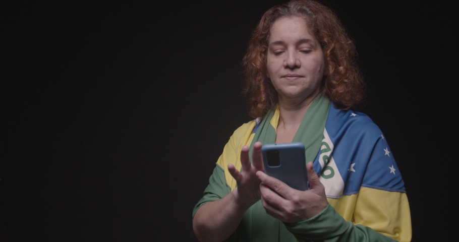 Woman supporter of Brazil, fan of Brazil, World Cup, Olympics, moving, browsing and talking on the cell phone. technology