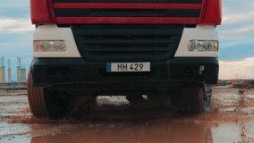 A construction truck drives through muddy ground at night, headlights cutting through darkness, creating a powerful scene of hard work and determination in an industrial setting. - Powered by Shutterstock - Get 15% off with code: PIKWIZARD15