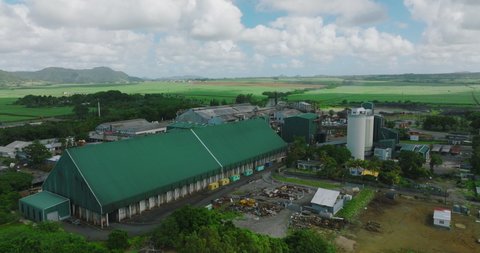 Aerial view of sugar factory in green sugarcane fields on Mauritius island. Sugar production.