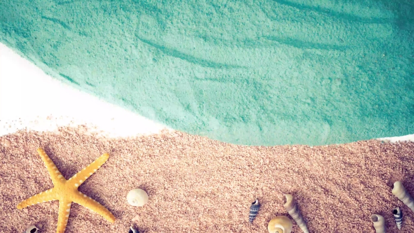 
stop motion of a sea wave that reveals a yellow starfish, conches and shells spread over the sand