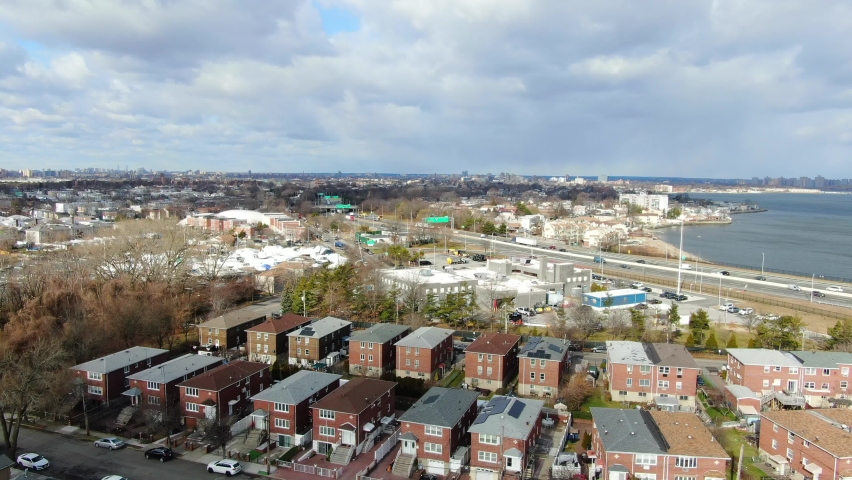 This is a distant aerial view of a neighborhood of homes in Park of Edgewater, NY.  This location is in The Bronx near the Throgg’s Neck Bridge.  | Shutterstock HD Video #1091082611