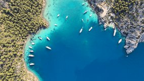 Aerial 4k drone video of daily tour boats and private yachts anchored in Cennet Bay, located in Selimiye village of Marmaris District of Muğla City, Turkey.