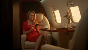 Pensive lady using smartphone on airplane golden sunlight. First class passenger resting check email social media on corporate trip. Beautiful blonde businesswoman hold gadget in luxury private jet. - Powered by Shutterstock - Get 15% off with code: PIKWIZARD15