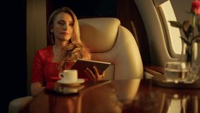 Beautiful woman surfing internet in sunlight jet. Closeup cabin interior details. Confident pensive lady traveling first class airplane. Attractive blonde professional using digital tablet chat online - Powered by Shutterstock - Get 15% off with code: PIKWIZARD15