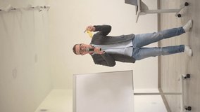 a man emotionally says something while standing at the blackboard and uses a banana.vertical video.