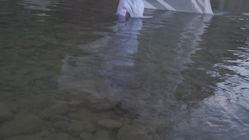 beautiful girl in the river with wet white dress