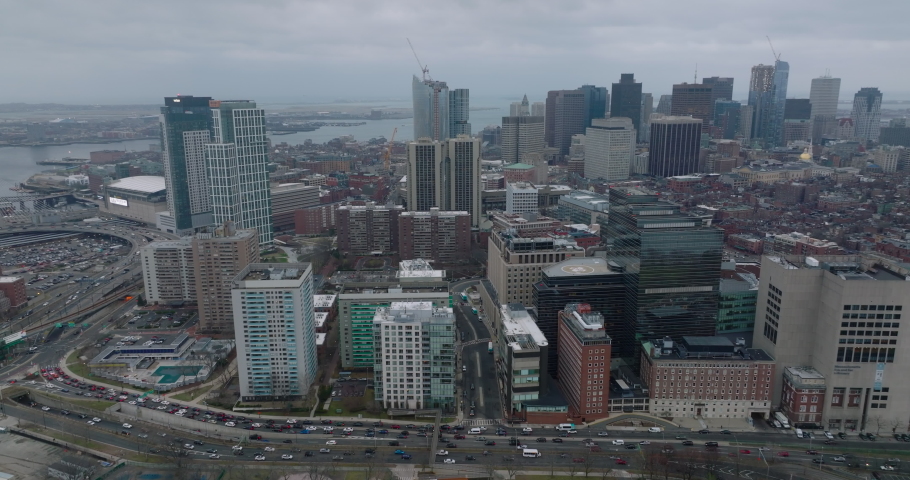Aerial shot of buildings in Massachusetts General Hospital area and downtown office towers in background. Backwards reveal of busy road on waterfront. Boston, USA Royalty-Free Stock Footage #1091093301