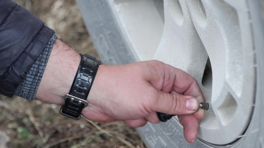 Wheel pressure measurement with electronic pressure gauge, close-up hands 4k