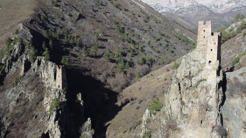 The watchtowers in mountains on rock at the entrance to the gorge. Historical towers in Caucasus mountains, view from above 4k