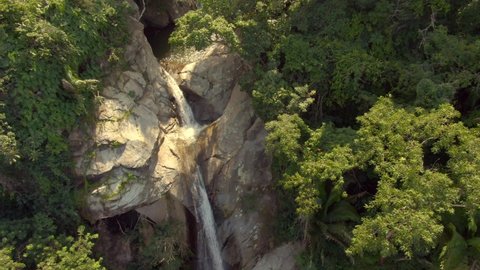 Waterfall Flowing From Sheer Rocky Mountains With People Swimming In Yelapa, Jalisco, Mexico. Tilt-down Shot