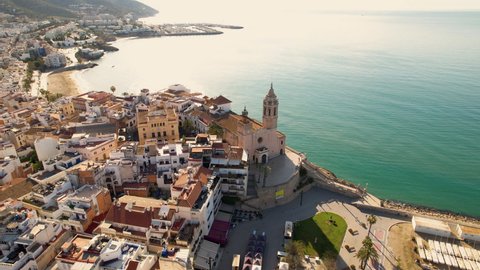 Aerial view of Sitges coastal village and Iglesia de San Bartolomé y Santa Tecla during a sunny day